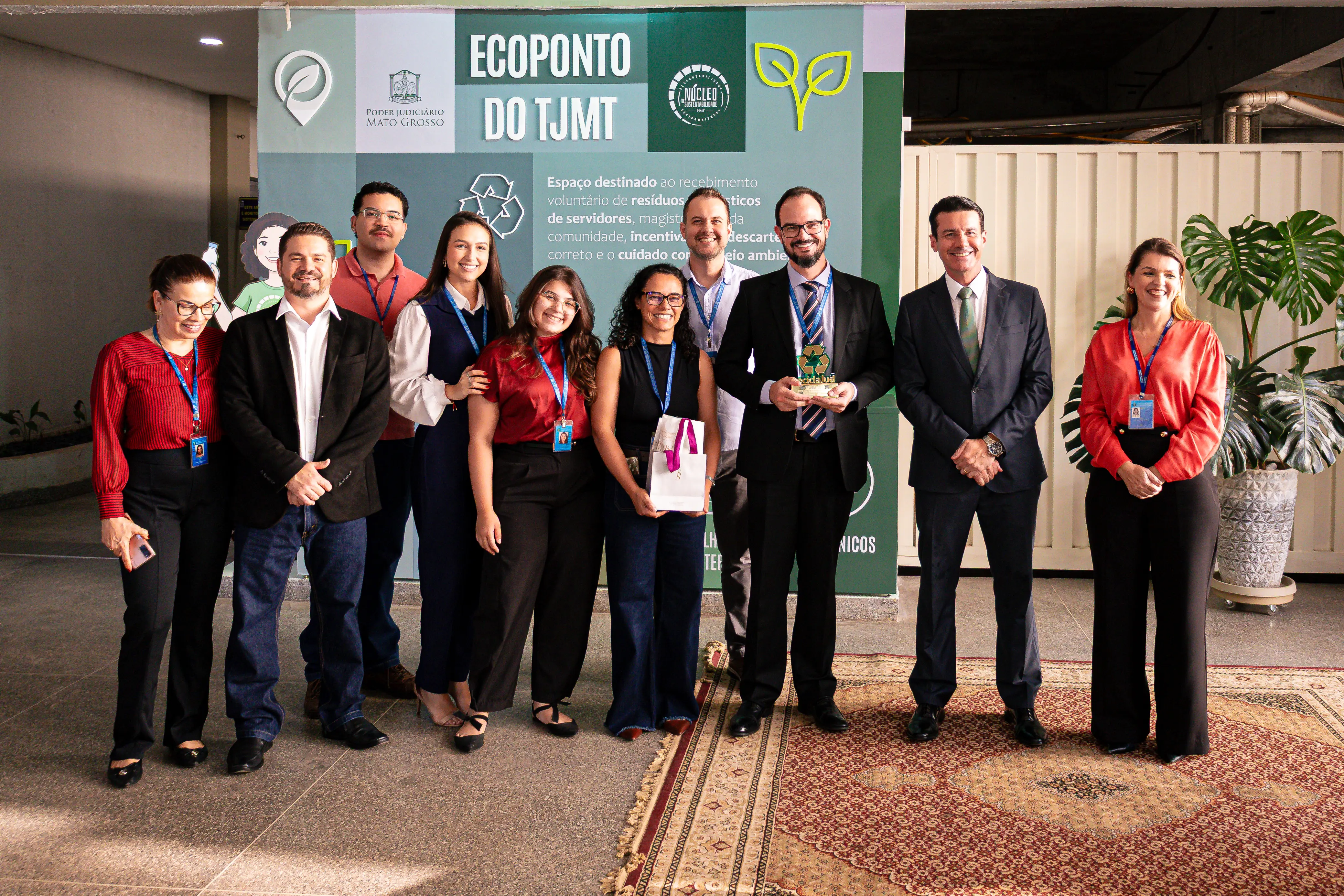 Integrantes do gabinete do desembargador Rodrigo Roberto Curvo posam para foto após receber o troféu de primeiro lugar do ReciclaJud, em frente ao ecoponto revitalizado do Tribunal de Justiça de Mato Grosso.
